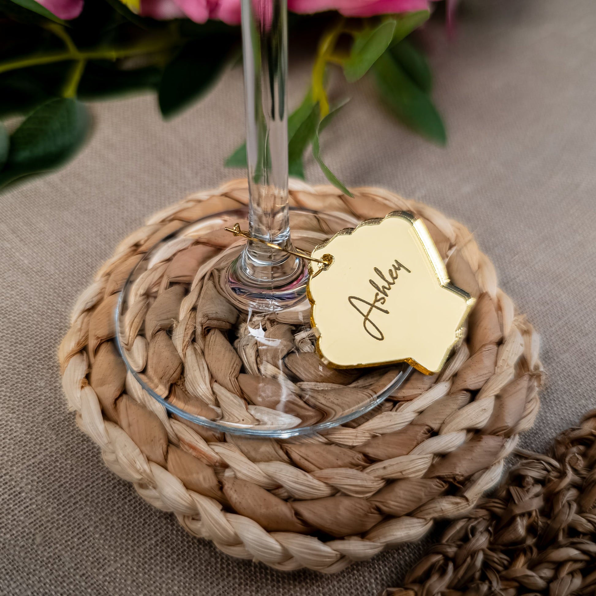 Sea shell wine charm attached to champagne glass with engraved name