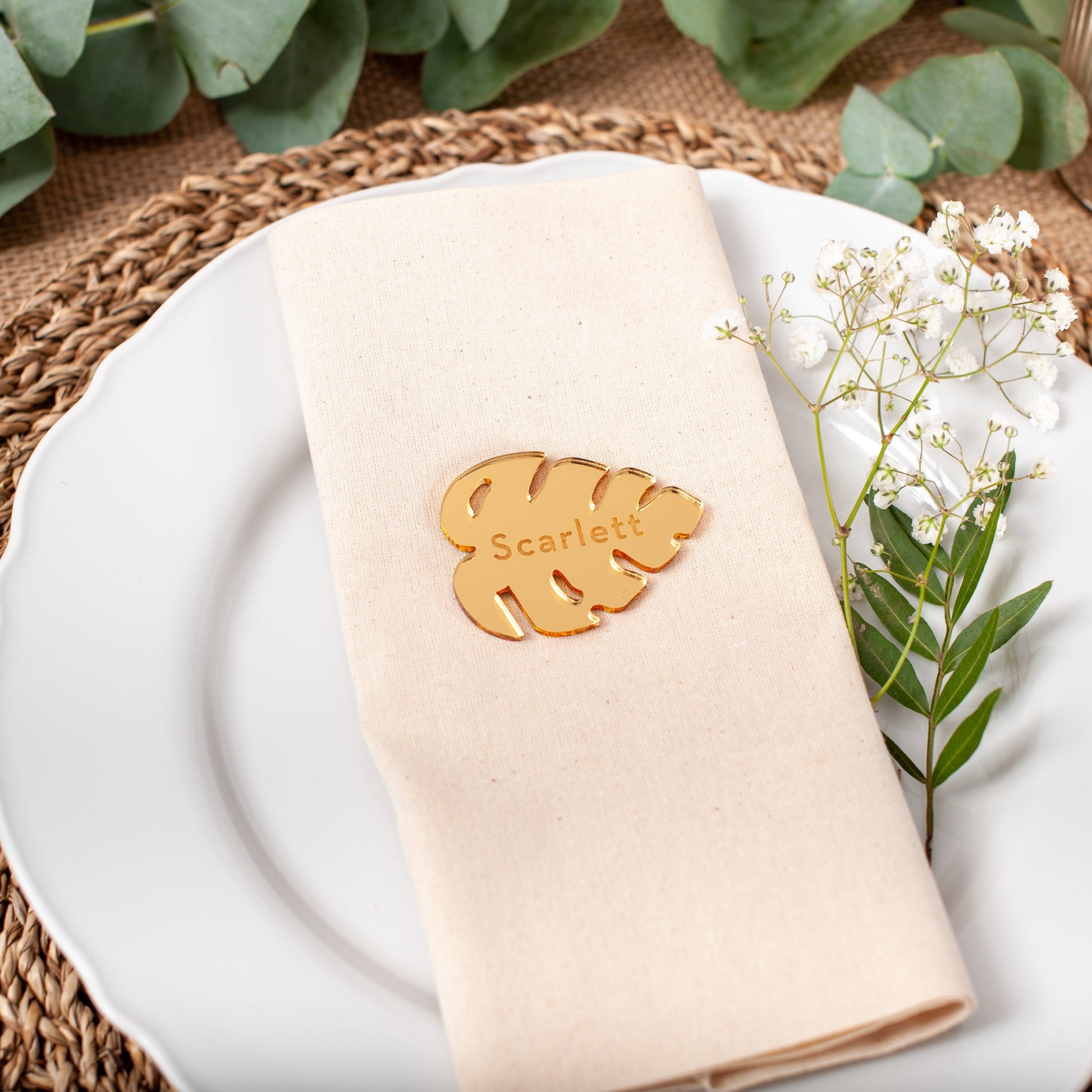 Personalised gold mirrored acrylic monstera leaf place card with engraved guest name