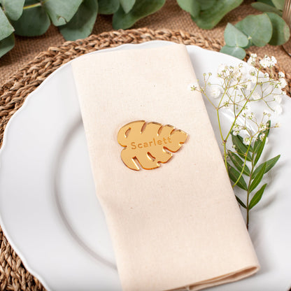 Personalised gold mirrored acrylic monstera leaf place card with engraved guest name