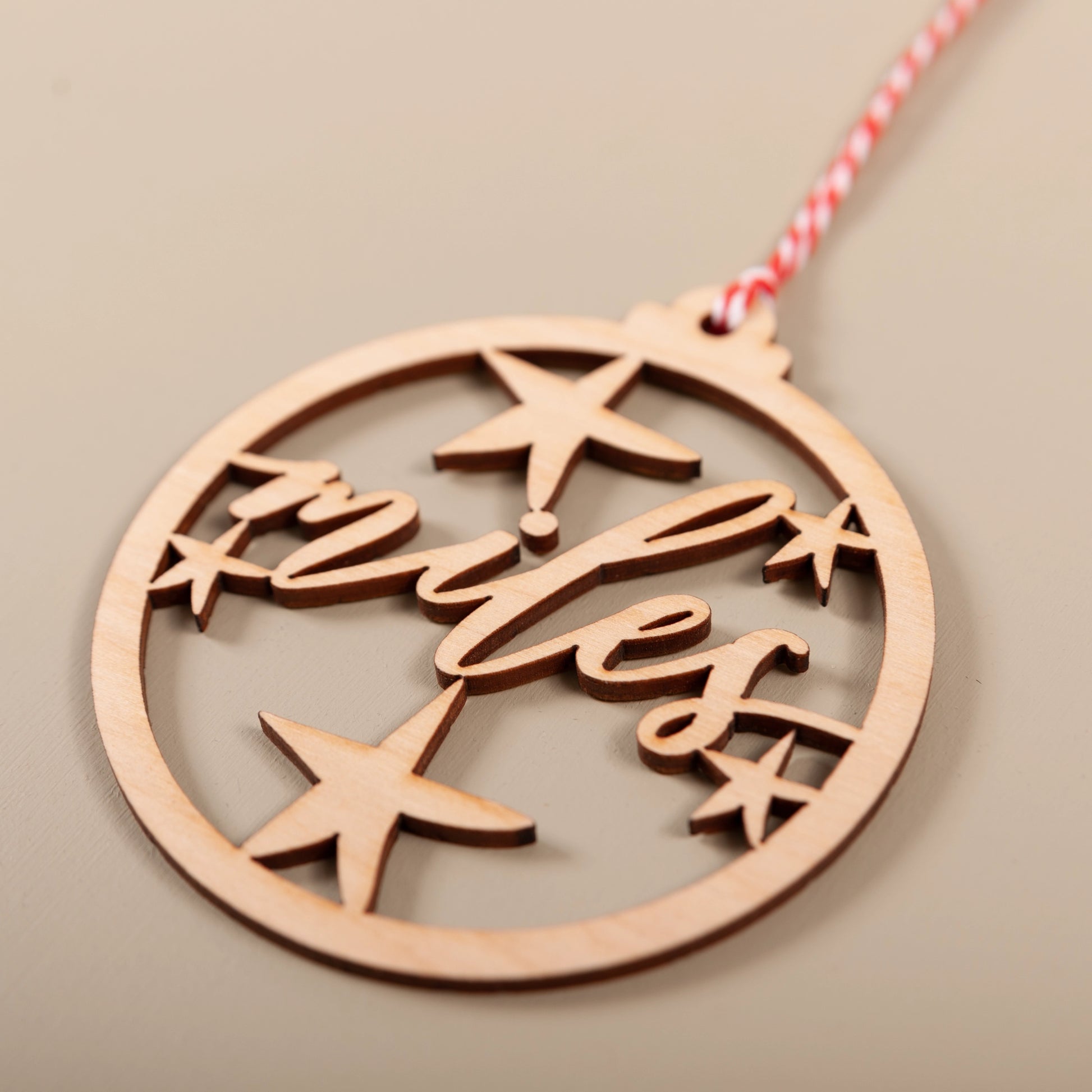 Elegant wooden personalised Christmas decoration with red and white twine