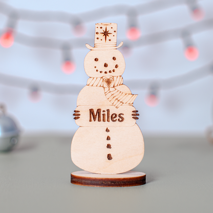 Wooden snowman place name ornament for winter wedding or festive dinner